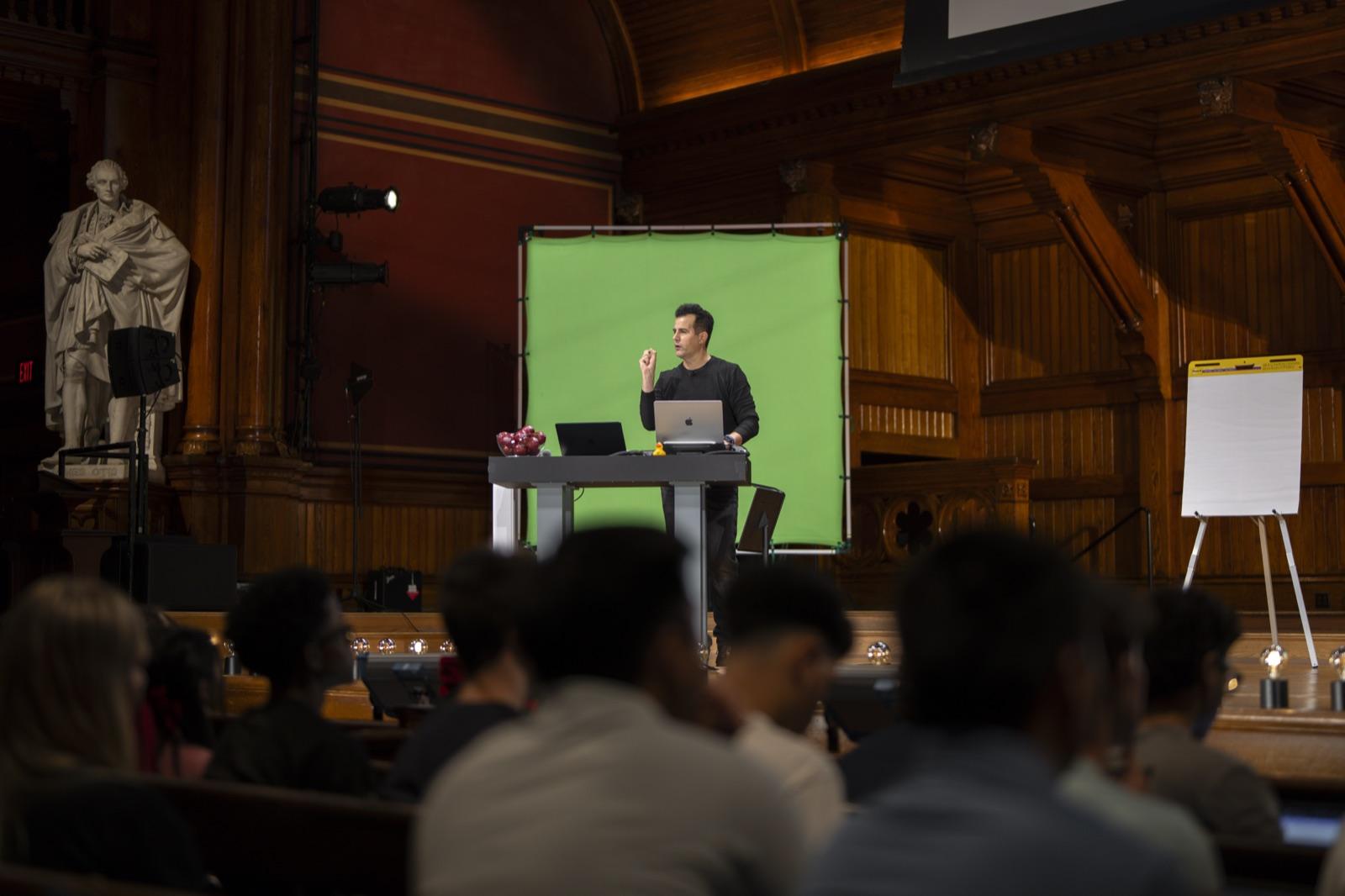 Maxim presenting a CS50 lecture on stage at Harvard
